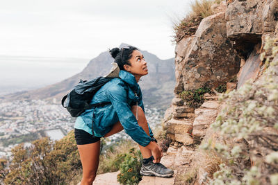 Side view of woman climbing on rock