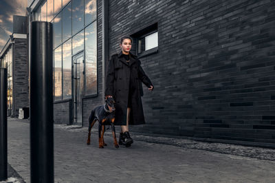 Teen girl walking down the street with her doberman. great view.  security and confidence concept