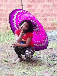 Full length of a smiling young woman in rain