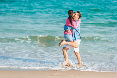 Rear view of woman standing at beach