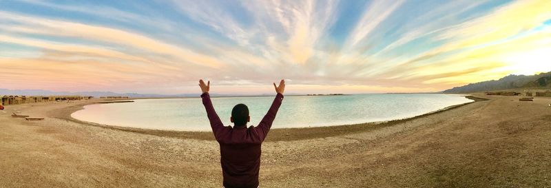 Scenic view of man on beach against sky