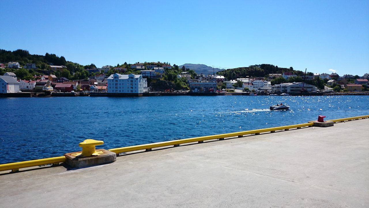 water, clear sky, built structure, building exterior, architecture, copy space, blue, nautical vessel, mountain, transportation, sea, river, railing, boat, nature, mode of transport, incidental people, day, scenics