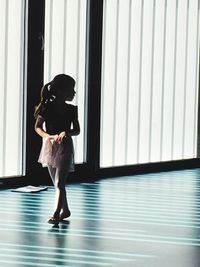 Full length of ballerina walking in ballet studio