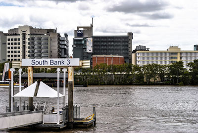 Jetty in lake against buildings