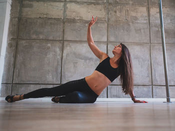 Sensuous woman dancing while lying on floor