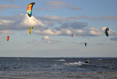 Man kiteboarding on sea against sky