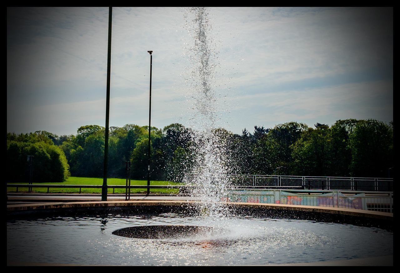 FOUNTAIN AGAINST TREES AND SKY