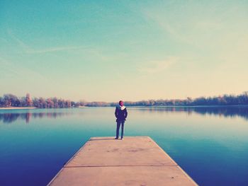 Man standing on jetty against lake