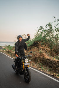 Man riding motor scooter on road