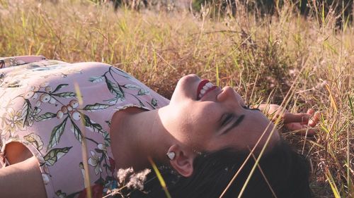 Smiling young woman lying on grassy field