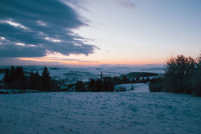 Scenic view of snowcapped landscape against sky during sunset