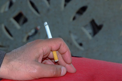 Close-up of hand holding cigarette