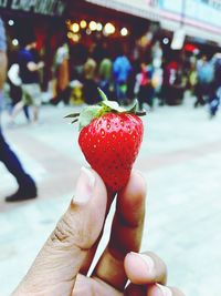 Close-up of hand holding strawberry