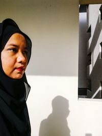 Close-up of woman standing against wall