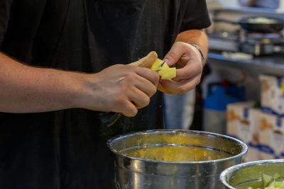 Cook cutting potatoes into small pieces to make the typical spanish meal, tortilla de patatas. 