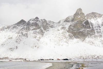 Scenic view of snowcapped mountains by sea against sky