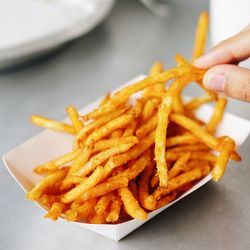 Cropped hand holding fried potatoes