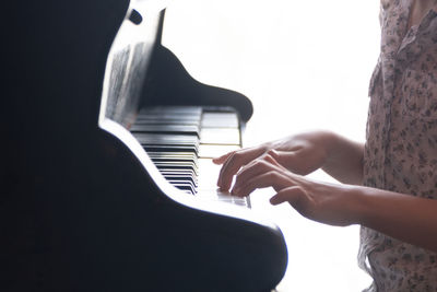 Midsection of woman playing piano