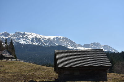 Built structure on snowcapped mountains against clear sky