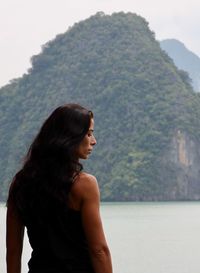 Young woman looking away while standing on mountain