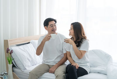 Young couple sitting on wall