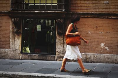 Full length of woman on footpath in city