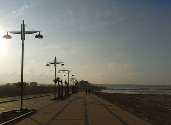 People walking on promenade against sky