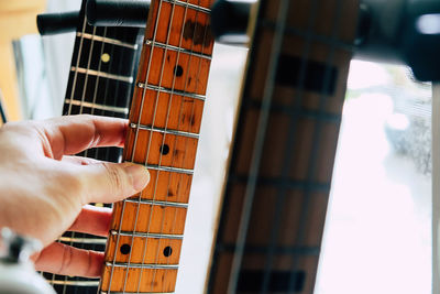 Midsection of person playing guitar at music concert