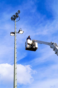 Low angle view of street lights against blue sky