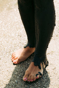 Low section of man standing on sand