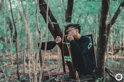 Full length of man drinking glass in forest