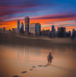 View of city buildings against cloudy sky during sunset