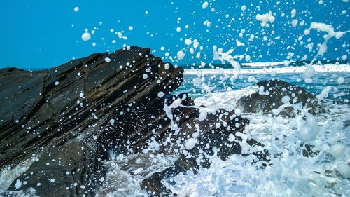 Panoramic view of sea waves splashing on rocks