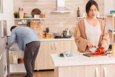 Young woman standing on table at home