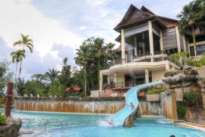 Swimming pool by trees against sky