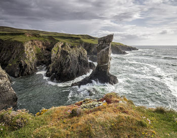 Scenic view of rocks in sea against sky