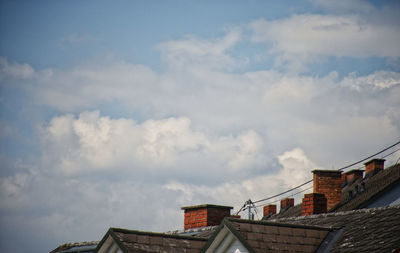 Low angle view of buildings against cloudy sky