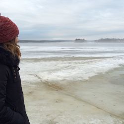 Side view of woman standing at beach against sky