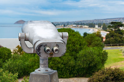 Close-up of coin-operated binoculars against sky