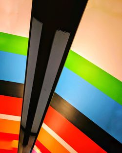Low angle view of multi colored umbrella against blue sky
