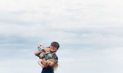 Happy girl holding hands against sky