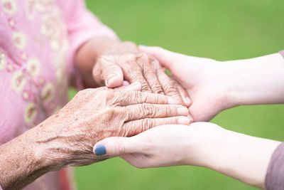 Close-up of woman holding hands of mother