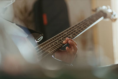 Midsection of man playing guitar