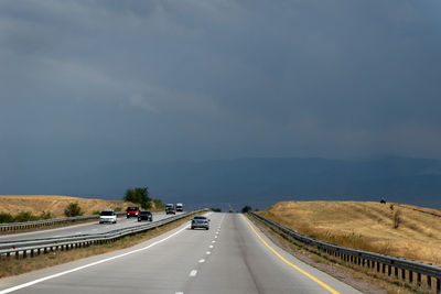 Cars on highway in city against sky