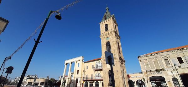 Low angle view of buildings against clear blue sky