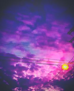 Low angle view of silhouette electricity pylon against sky during sunset