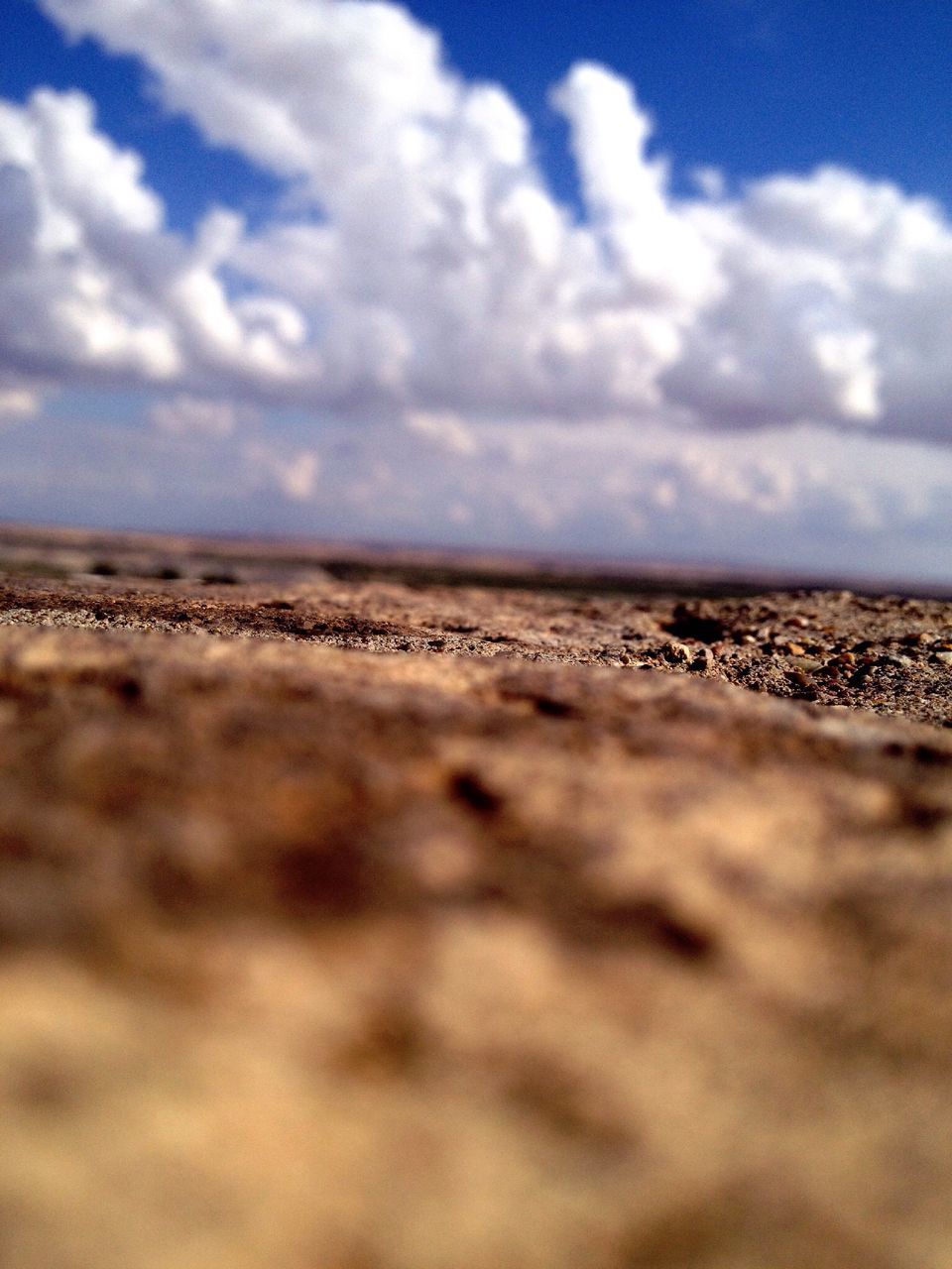 sky, surface level, landscape, tranquil scene, sand, tranquility, cloud - sky, cloud, nature, scenics, beach, horizon over land, beauty in nature, selective focus, cloudy, desert, day, outdoors, remote, arid climate