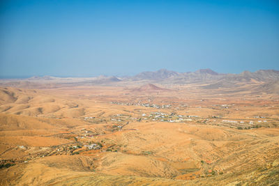 Scenic view of desert against clear blue sky