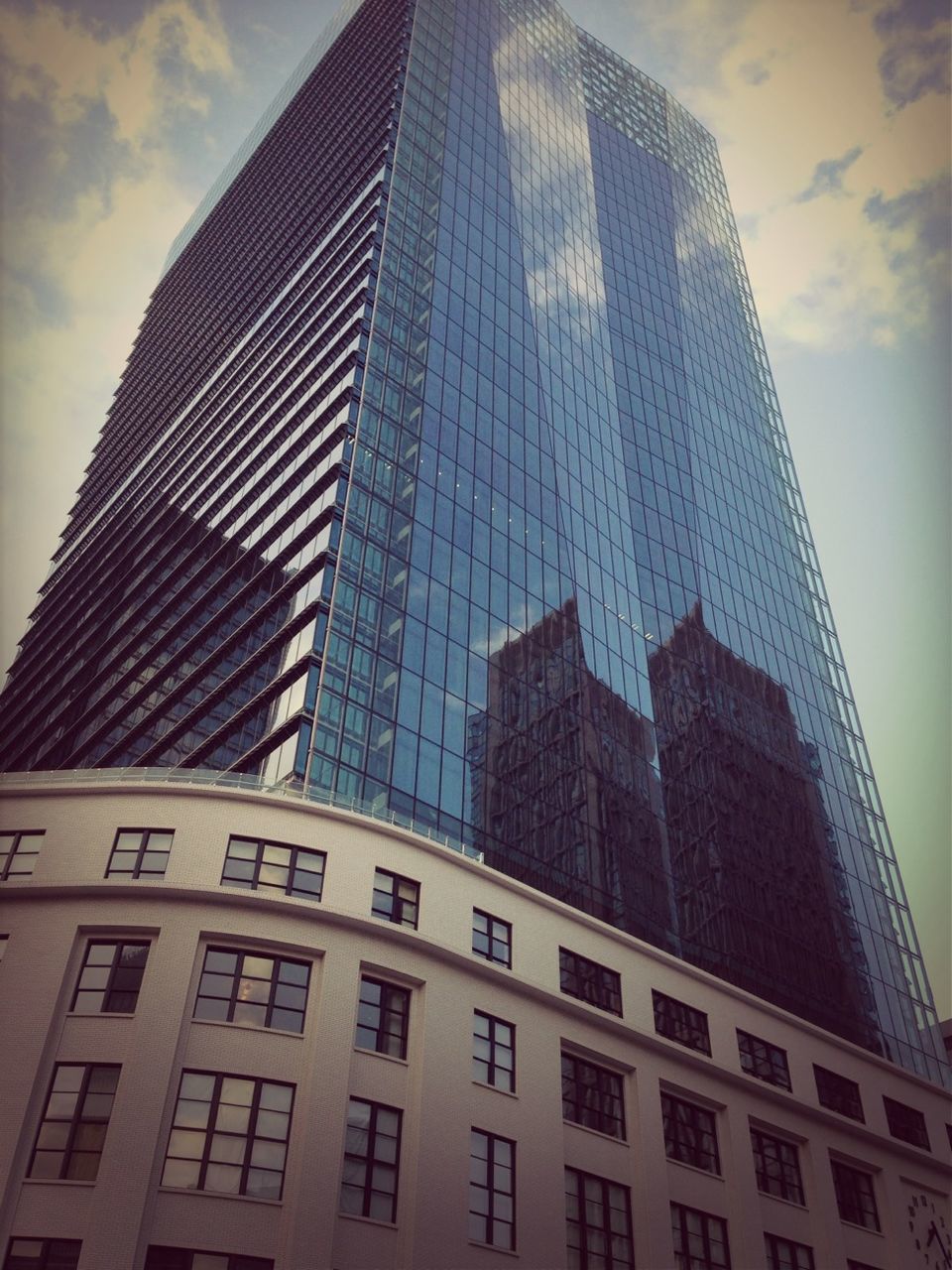 architecture, building exterior, built structure, low angle view, modern, office building, skyscraper, city, tall - high, sky, glass - material, tower, building, cloud - sky, reflection, window, tall, day, no people, city life