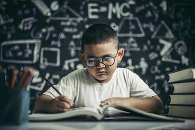 Portrait of boy with open book in background